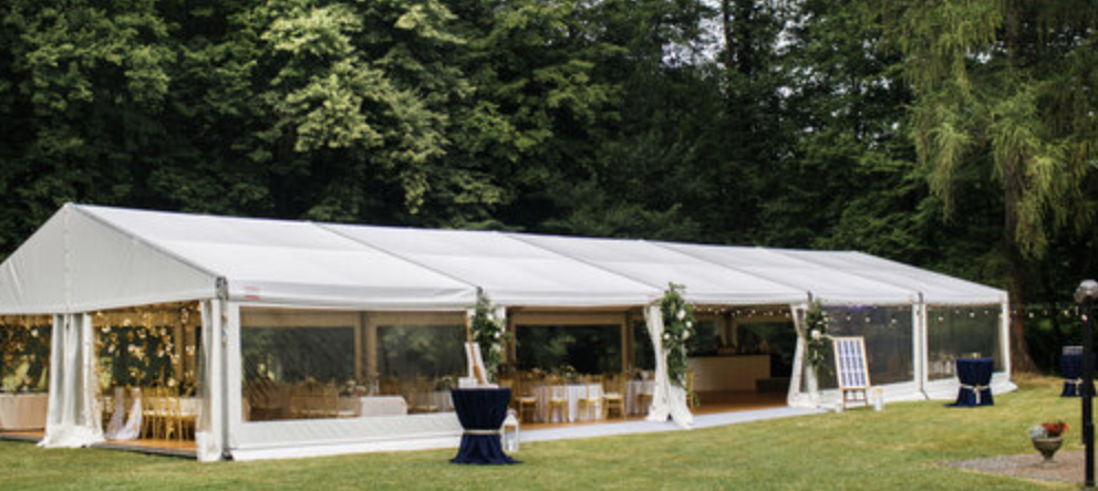 Clear-top wedding tent with chandeliers and dining setup